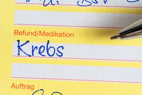Eine ärztliche Bescheinigung, bei der unter Befund/Medikation das Wort "Krebs" eingetragen ist.