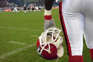 Ein Spieler der Cologne Centurions beobachtet das Spielgeschehen von der sideline American Football Herren NFL Europe League 2004. Er hält seinen Helm in der Hand.