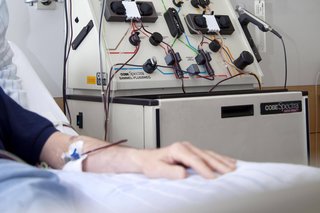 Ein Patient bei einer Stammzellentransplantation, hier in einem Krankenhaus in Essen, NRW. Die Person liegt im Bett in einem Krankenhauszimmer und hat einen Zugang im Arm. 