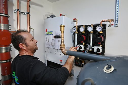 Ein Heizungsmonteur arbeitet an einer Heizungsanlage.